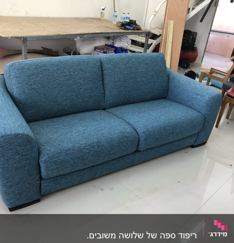 ספה כחולה עם ריפוד עבה בחדר עבודה